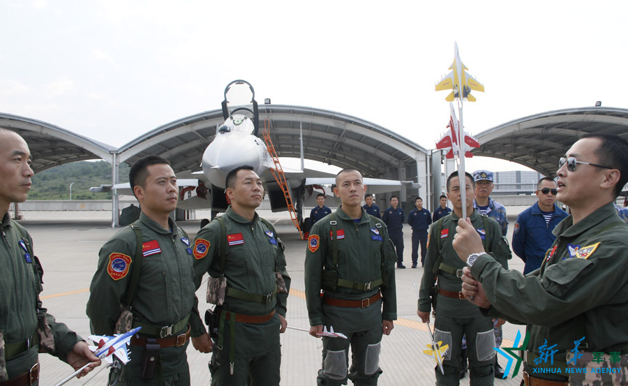 &uarr;艦載航空兵某部司令員戴明盟向飛行員演示空中飛行注意事項(xiàng)。