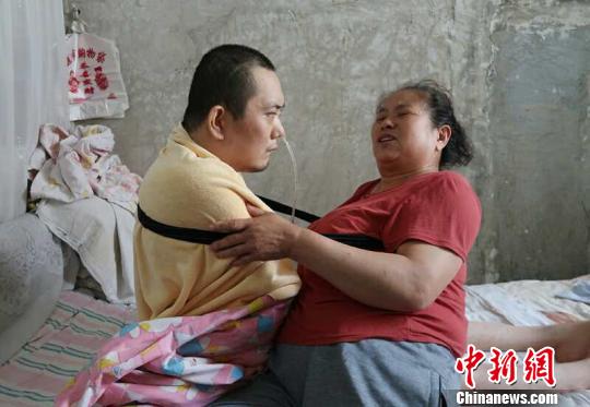 身體日漸衰老的梁青蘭每次幫兒子翻身、坐立，全身的衣物都要濕透一次。　尚明俠 攝
