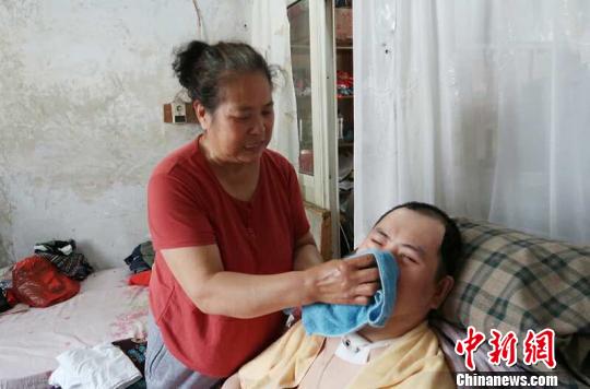 每次喂完食物后，梁青蘭都要仔細(xì)地幫兒子清理干凈?！∩忻鱾b 攝