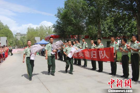 部隊官兵們迎接出院歸來的李運飛(中)和其他消防戰(zhàn)士?！⊥粲?攝