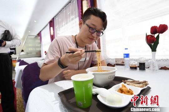 圖為旅客在列車上享用正宗牛肉面?！钇G敏 攝