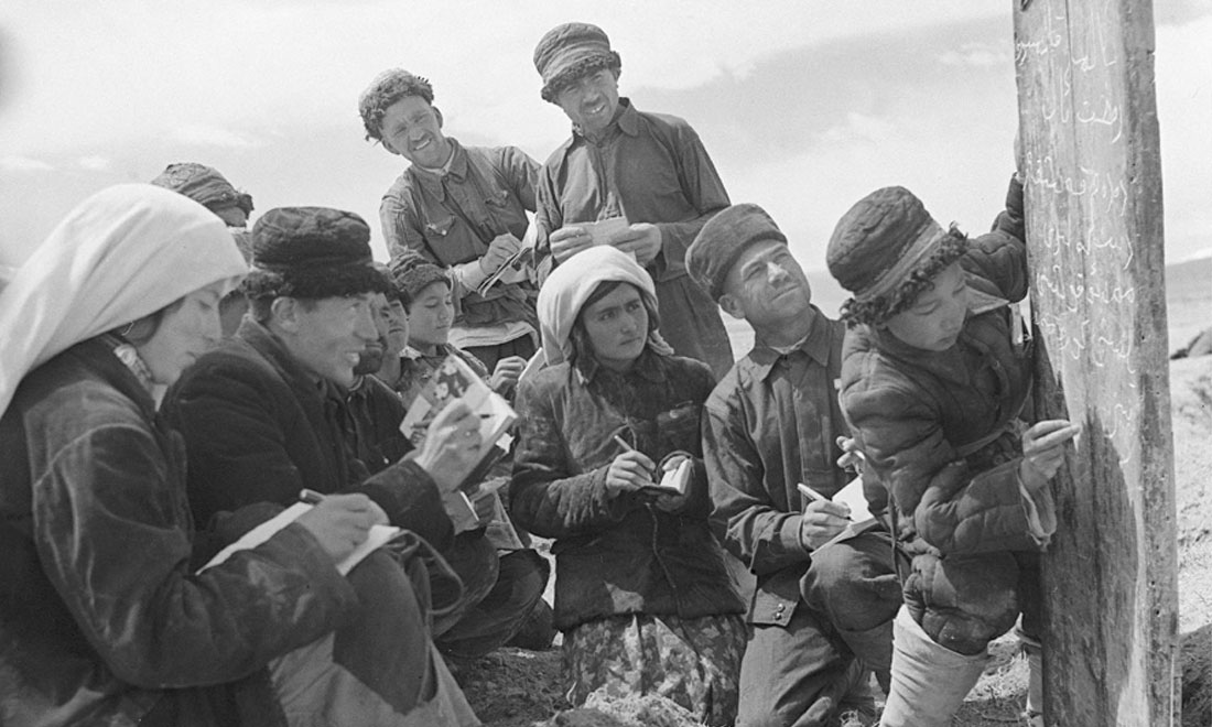 1960年6月，新疆慕士塔格峰下，大人們在小學(xué)生幫助下學(xué)習(xí)文化。新華社記者武純展攝